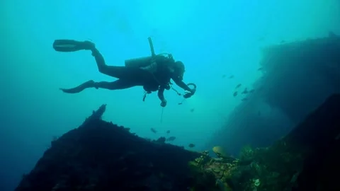 Diving Bali. Diver floats in a ship wreckage Stock Footage 130375973
