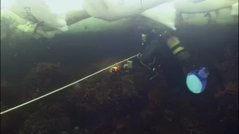 Diving beneath the ice of the white sea in the arctic ocean Stock Footage 314132525