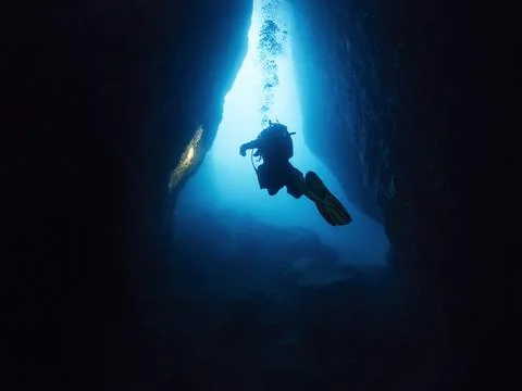 Diving between the rocks of an underwater cave Stock Photos
