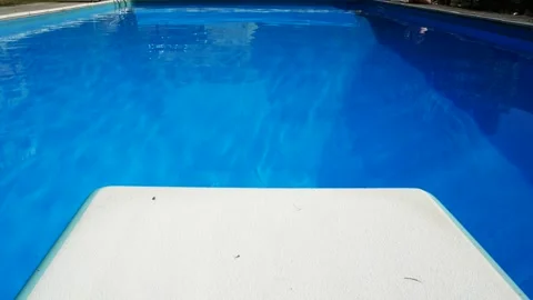 The diving board in a swimming pool, with blue waters. Stock Footage 332057972