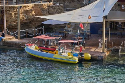 Diving boat moored at a dockside cafe in a coastal Mediterranean town Stock Photos