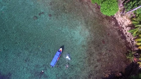 Diving into crystal clear waters from the deck of a boat drone view Stock Footage 90523885