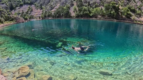 Diving in deep bay next to a shipwreck Stock Footage 338375005