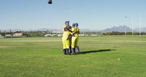 Diving fielder securing final out with ground ball prompting male teammates Vídeos de archivo 343512601