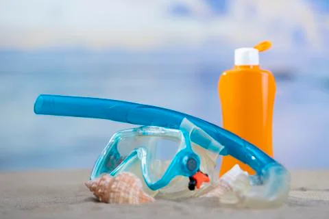 Diving goggles with seashells and a sunscreen bottle Stock Photos