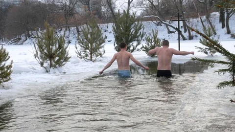 Diving into the hole in baptism. Orthodox holiday baptism. people dive in cold w Stock Footage 101416541