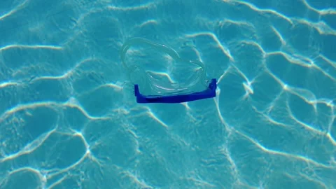 A diving mask floating on the surface of clear swimming pool water. Stock Footage 245064885