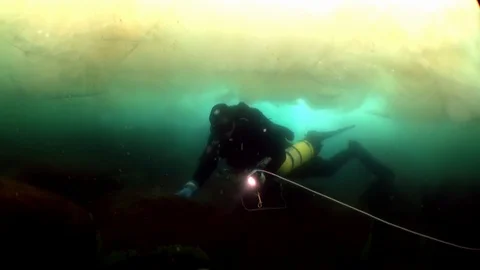 Diving under ice underwater of lake Baikal. Video stock 100179210