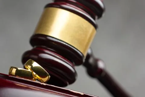 Divorce and separation concept. Two golden wedding rings, judge gavel. Stock Photos