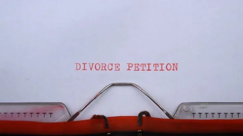 Divorce petition - phrase printed on an old typewriter in red letters, close up. Vídeos de archivo 129536048