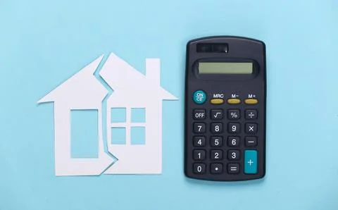 Divorce, property division concept. Split paper house and calculator on blue  库存照片