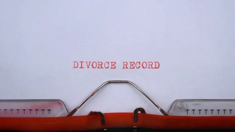 Divorce record - phrase printed on an old typewriter in red letters, close up. Видео 129536060