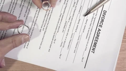 Divorcing couple puts their wedding rings on divorce document. Stock Footage 145992418