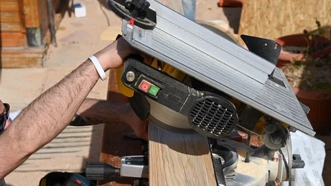 Diy boy with tattoo, hat and glasses uses the circular saw Stock Footage 107748205