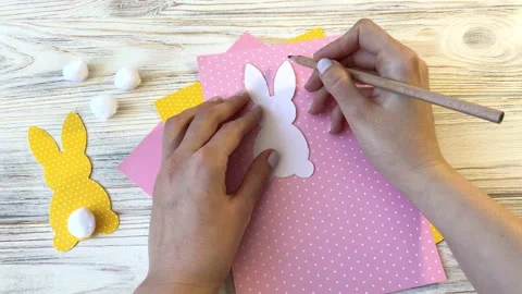 DIY Easter decor, step by step, step 2, hands cut a hare out of paper Stock Footage 148826102