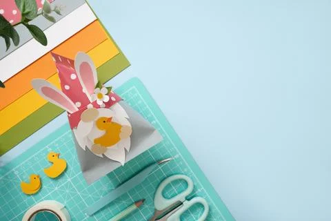 DIY Easter gnome with bunny ears and paper ducks. Scissors, cutting mat, and  Stock Photos