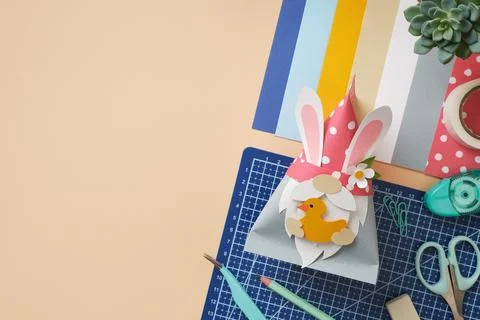 DIY Easter paper gnome with bunny ears holding a yellow duck. Creative worksp Stock Photos