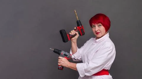 DIY enthusiast shows multitasking capability with dual screwdrivers. Red cu.. Stock Photos