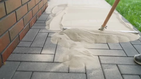 DIY home improvement to back yard. Filling paving joints, Brushing dry sand Stock Footage 228652410