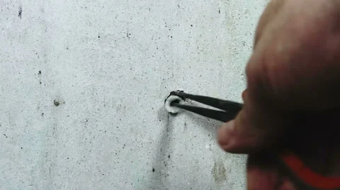 DIY man removing stubborn old wallplug from interior wall while re-decorating Stock Footage 56634612