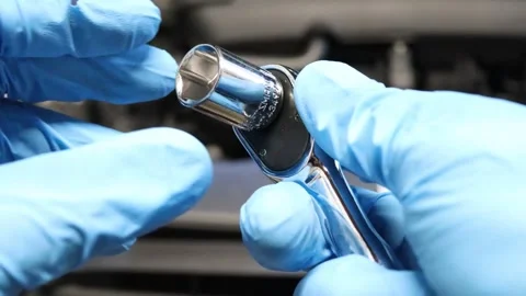 DIY mechanic at home removing a socket from a socket wrench Stock Footage 244487635