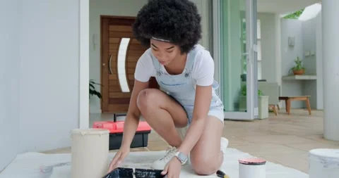 DIY painter is tipping paint bucket, pouring into tray, then painting porch wall Stock Footage 340011455