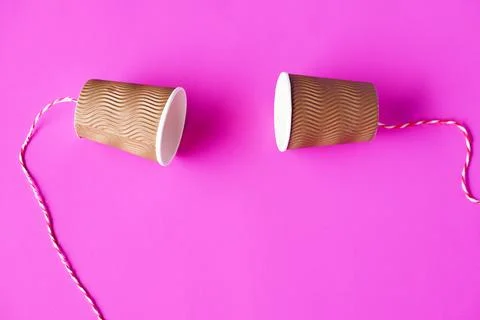DIY paper cups with string on pink background. Concept, telephone toy. Concept,  Stock Photos