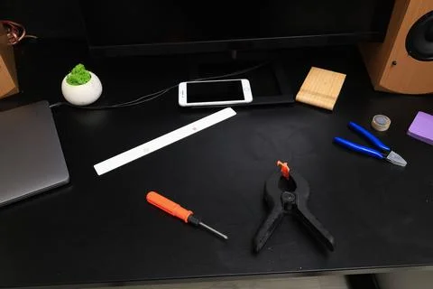 DIY project setup on a black desk with tools and electronics Stock Photos