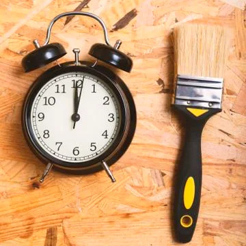 DIY time concept. Tools surrounding a black alarm clock Stock Photos