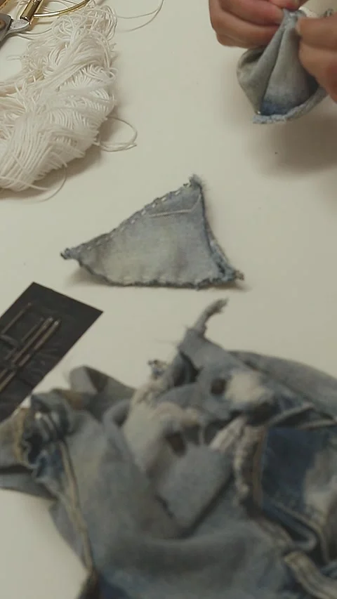 DIY tutorial showing turning a sewn triangle denim inside out Stockbeeldmateriaal 294921497