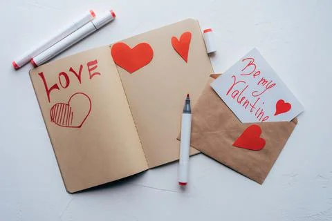 DIY valentine in an envelope and a declaration of love in a sketchbook. Stock Photos