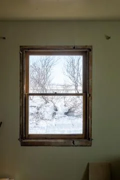 DIY window insert install in old house with wintery snow and trees in view Foto stock