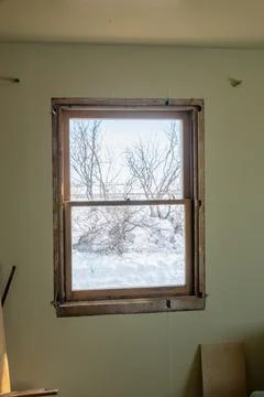 DIY window insert install in old house with wintery snow and trees in view Foto stock