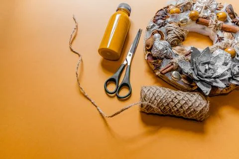 DIY wreath with an abundance of elements next to scissors, paint and twine. Stock Photos