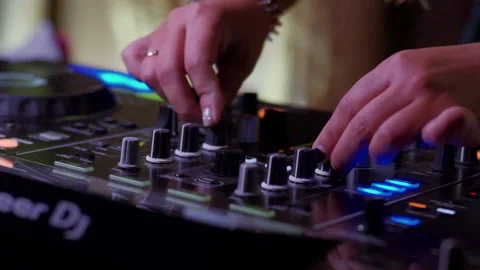 A DJ adjusting the knobs of her mixer 動画素材 149203295