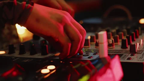 DJ cheerfully adjusting the knobs of the mixer during the party with the color Stock Footage 279564262