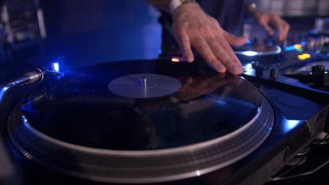 DJ CLOSE UP OF HAND MIXING AND SCRATCHING VINYL, BLUE LIGHT BACKGROUND Stock Footage 128323897