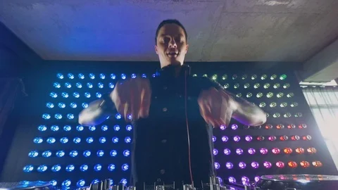A DJ in close view turns knobs with both hands. Video stock 79201422