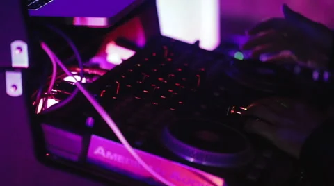 DJ at a console booth spinning CDs and moving mixer faders and knobs. Vidéo 61076678