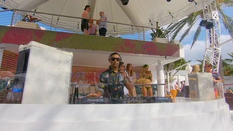 Dj djing, dancing and having fun working at Ocean beach club in Ibiza Stock Footage 128980945