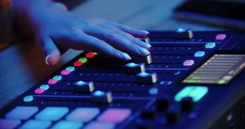 DJ hand operating illuminated audio mixer Stock Footage 315516962