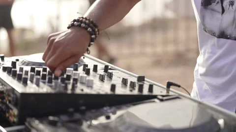 DJ handling controller close up with hands moving outdoors wearing a smart watch Stock Footage 239445754