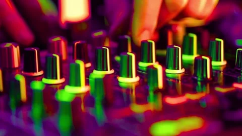 DJ hands adjusting knobs on mixer board under colorful lights Stock-Footage 341970327