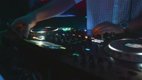Dj hands adjusting mixing console knobs and jog wheel, creating electronic music 库存影片 321802202