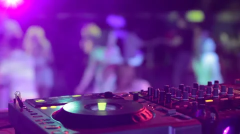 DJ hands and equipment during night club party with dancing people Stock Footage