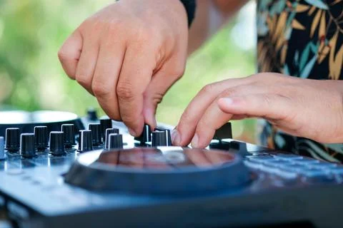 DJ Hands creating and regulating music on dj console mixer in beach club stage Stock Photos