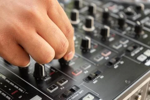 DJ Hands creating and regulating music on dj console mixer in concert party.. Stock Photos