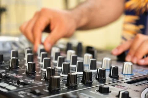 DJ Hands creating and regulating music on dj console mixer in concert party.. Stock Photos
