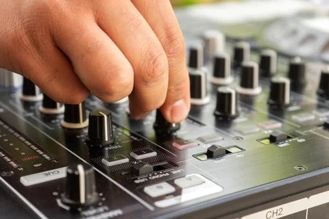 DJ Hands creating and regulating music on dj console mixer in concert party.. Stock Photos