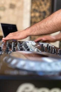 DJ Hands creating and regulating music on dj console mixer in concert party.. Stock Photos